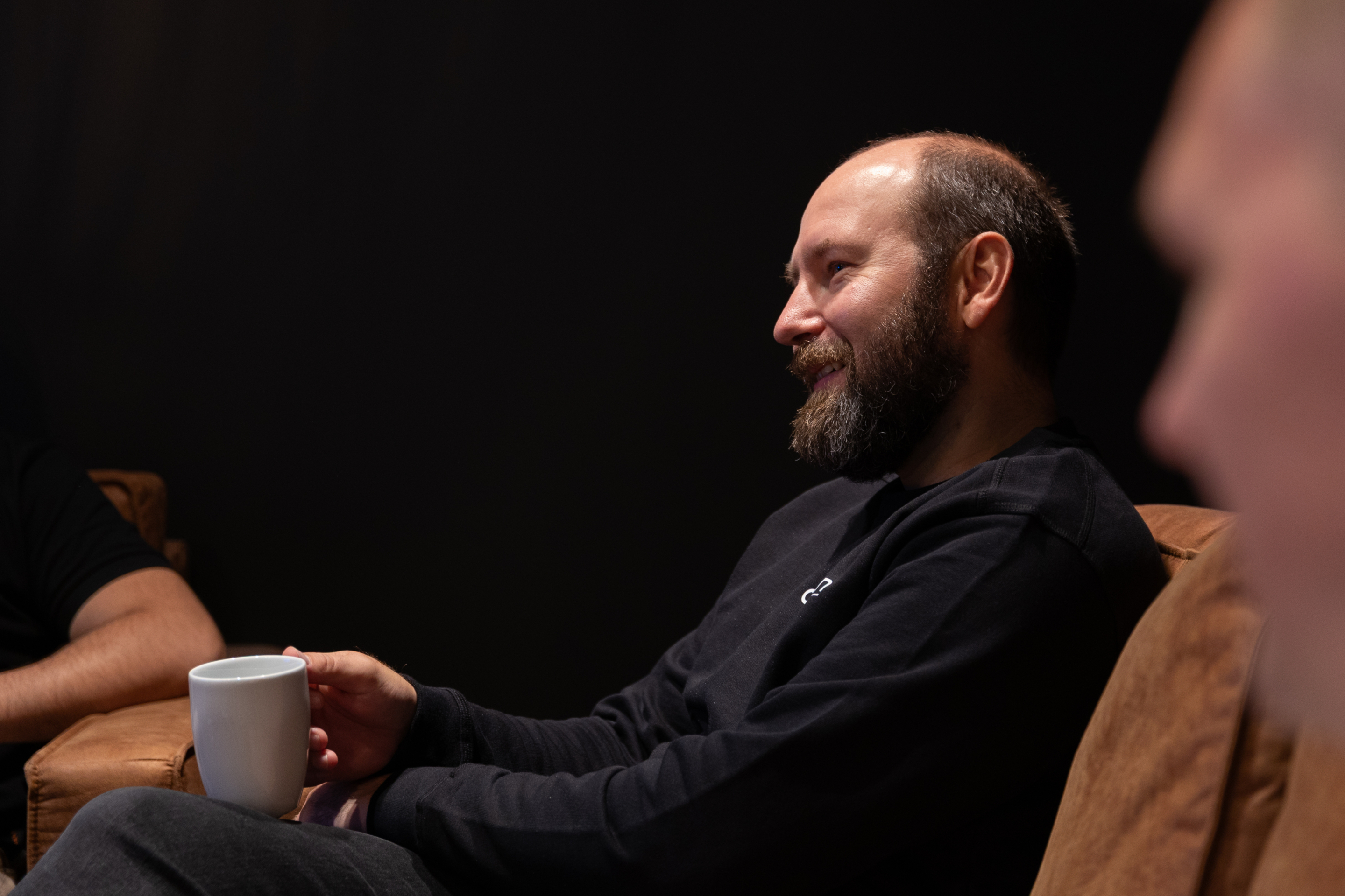 Mann i avslappet samtale med kaffekopp – uformell møteplass i Kristiansand Teknologipark